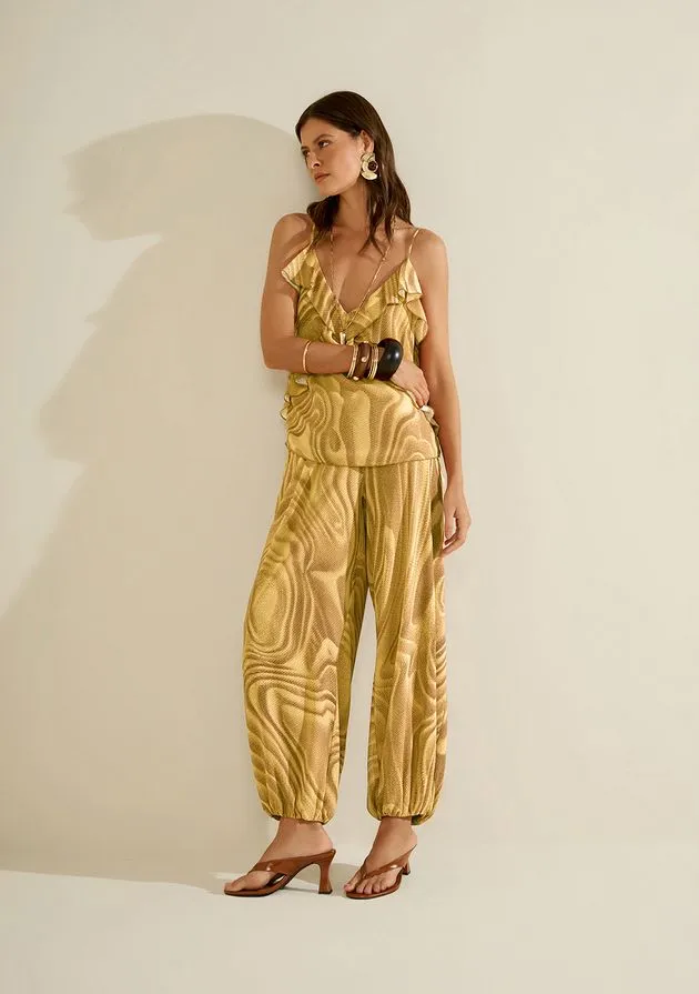 Modelo encostada na parede usando conjunto com estampa dourada