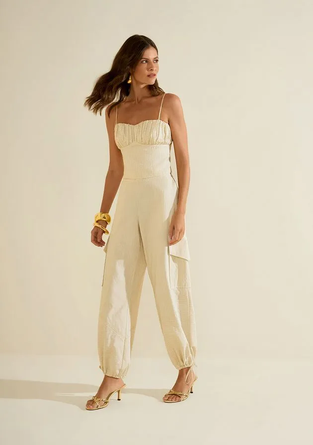 Modelo usando macacão off-white de alças com busto franzido